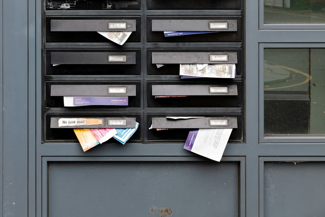 "A wall of numbered metal mailboxes with small locks lined up in a postal room."
